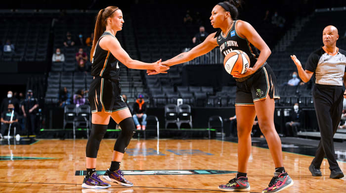 Sabrina Ionescu low-fiving Betnijah Laney